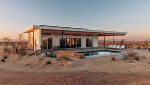 A modern house with a pool, surrounded by desert landscape. - The Refuge • Healing Retreat, Saltwater Pool & Spa (Joshua Tree)