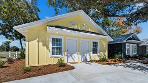 A yellow building with two white doors and a small porch area.