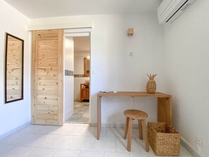 A minimalist room with a wooden desk, a stool, and a woven basket. - Villa Caméo • Grande villa familiale vue mer 180° (Le Gosier)