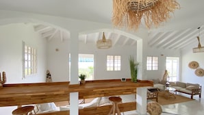 Un'ampia stanza con una panca di legno, un divano e un'area pranzo.