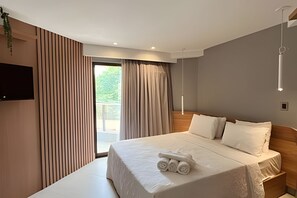 A modern hotel room with a large bed, a flat-screen TV, and a balcony with curtains. - Infinity At The Sea (João Pessoa)