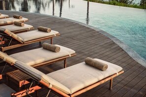 A poolside area with lounge chairs and a wooden deck. - Namia River Retreat - Wellness Inclusive Resort (Hoi An)