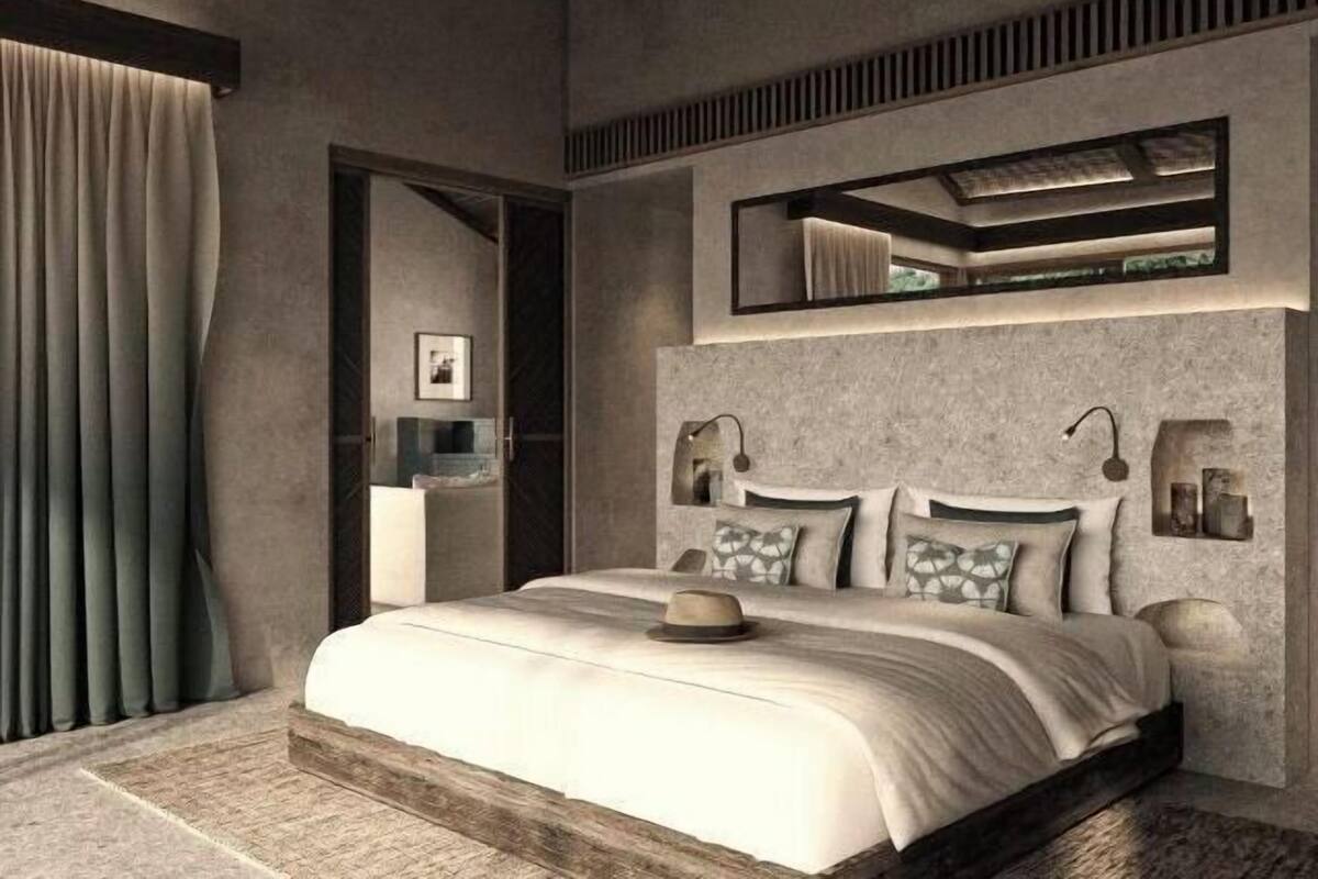 A modern bedroom with a large bed, a mirror above the bed, and a built-in shelf with decorative items.