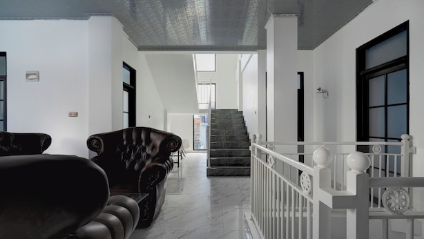 A spacious hallway with a marble floor, a staircase, and a white railing. - Hotel O 94843 Syariah Hj. Lilis Sukabumi (Sukabumi)