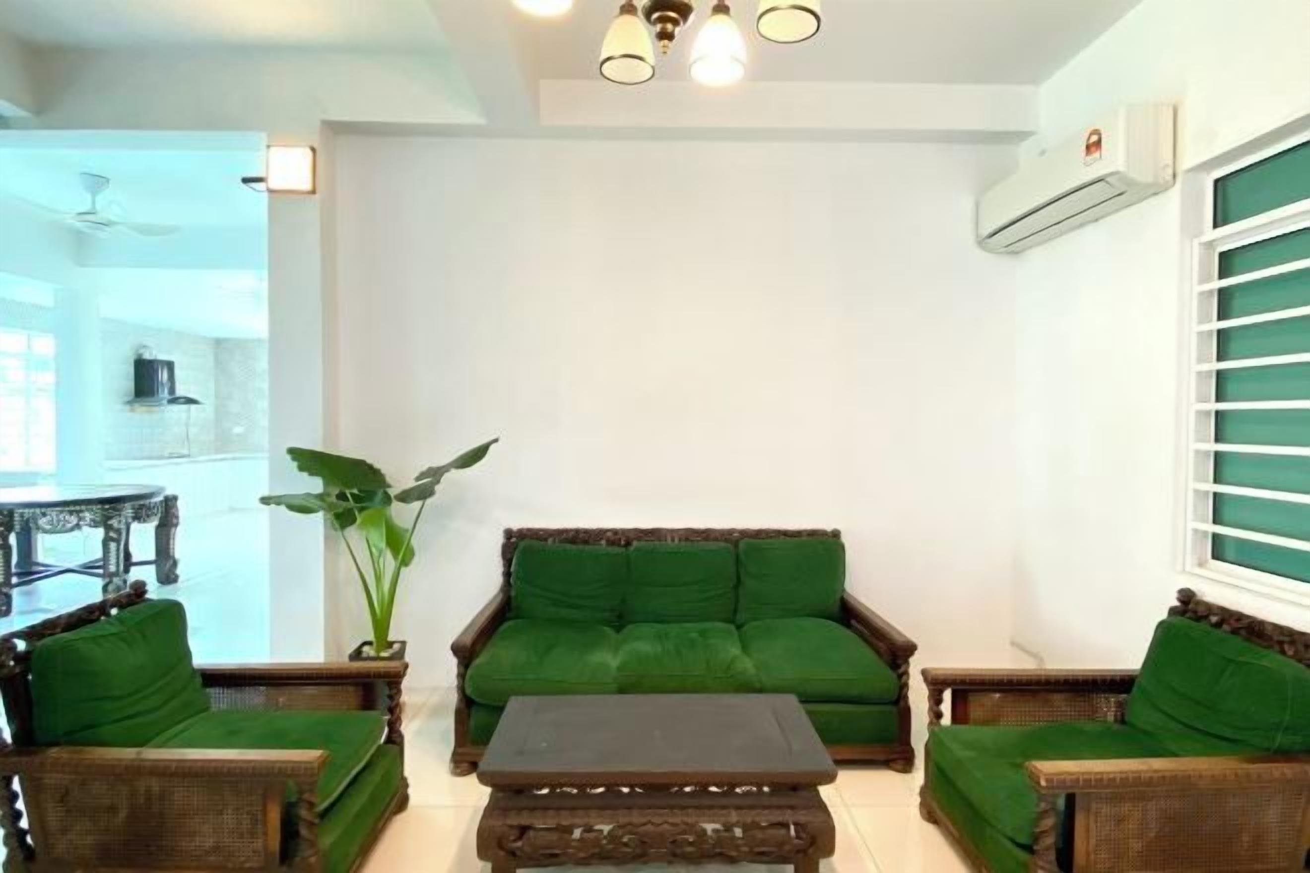 Una sala de estar con un sofá verde, una mesa de centro y una planta en maceta.