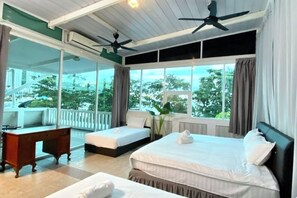 A hotel room with two beds, a desk, and a balcony with a view of trees. - Seahome Boutique Hotel (Tanjung Bungah)