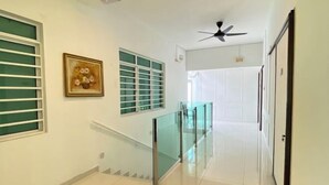 A hallway with a glass railing, a ceiling fan, and a staircase. - Seahome Boutique Hotel (Tanjung Bungah)