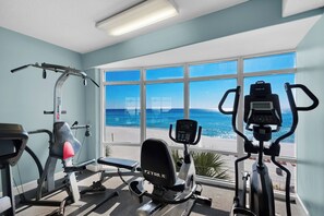 A gym with cardio machines and a view of the beach. - ☀️Gulf FRONT-Pools+Hot Tub-Beach Service-Emerald Isle 1406☀️ (Panama City Beach)
