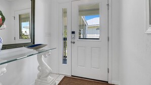 A white door with a glass panel and a keypad lock. - Flamingo Bayou A (Fort Myers Beach)