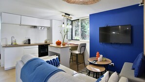 A modern apartment with a kitchen, dining area, and living room. - Bleu Rance - Studio à quelques minutes de la mer (Dinard)