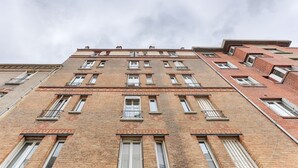 Ein mehrstöckiges Backsteingebäude mit zahlreichen Fenstern und Balkonen.