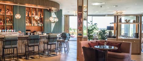 Zona de bar con diversas opciones de asientos y vistas al exterior.