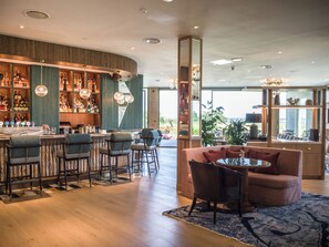 A bar area with multiple seating options and a view of the outdoors. - The Hawthorn By Galway Bay (Oranmore)