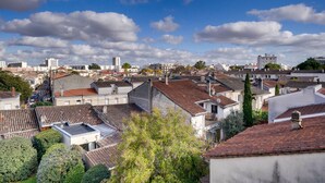 Un barrio residencial con diversos edificios, incluyendo casas y complejos de apartamentos, bajo un cielo parcialmente nublado.