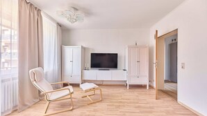 A modern living room with a flat-screen TV, two rocking chairs, and a cabinet. - Ida - Bergheim near Cologne (Bergheim)