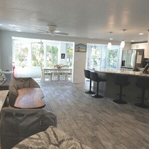 A spacious kitchen with a dining area, large windows, and a ceiling fan. - Weeki Wachee, Florida Entire Home on Natural Spring - 2 Bed 2 Bath (Weeki Wachee)