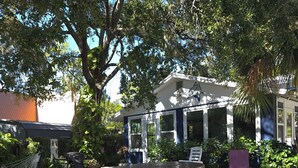 An outdoor seating area with a wooden table and chairs, surrounded by gravel and greenery. - Weeki Wachee, Florida  Entire Home on Natural Spring - 2 Bed 2 Bath (Weeki Wachee)