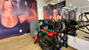 A gym with weightlifting equipment, a treadmill, and a large mirror. - Gold Flat  (João Pessoa)