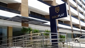 A hotel entrance with a sign reading 'GOLDFLAT,' a modern building facade, and a car parked in front. - Gold Flat  (João Pessoa)