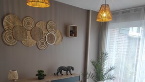 A dining area with a long table, chairs, and two hanging pendant lights. - L'essentiel en campagne (Calais) Farmhouse 10 minutes from the beach! Private Parking! (Guemps)