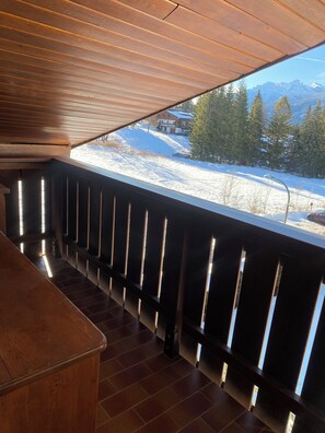 A wooden interior with a view of a snowy landscape and mountains. - 360-DEGREE PANORAMIC ATTIC IN THE PEARL OF THE DOLOMITES (Cortina d'Ampezzo)