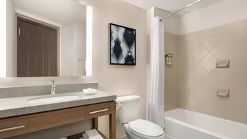 A modern bathroom with a sink, toilet, and bathtub.