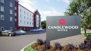 A hotel sign for Candlewood Suites with a modern building in the background. - Candlewood Suites Mankato East By Ihg (Mankato)
