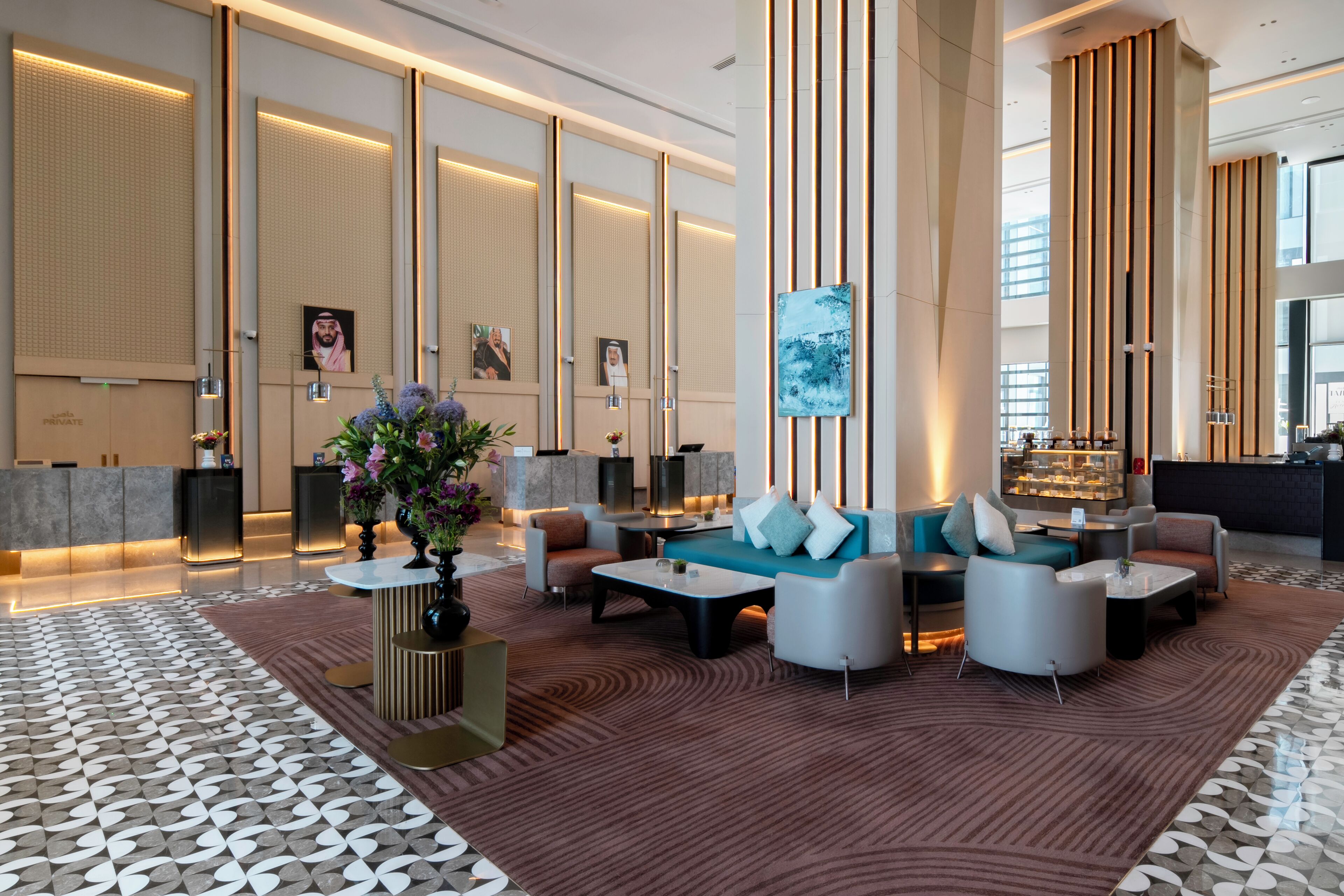 A modern lobby with a reception desk, seating area, and artwork.