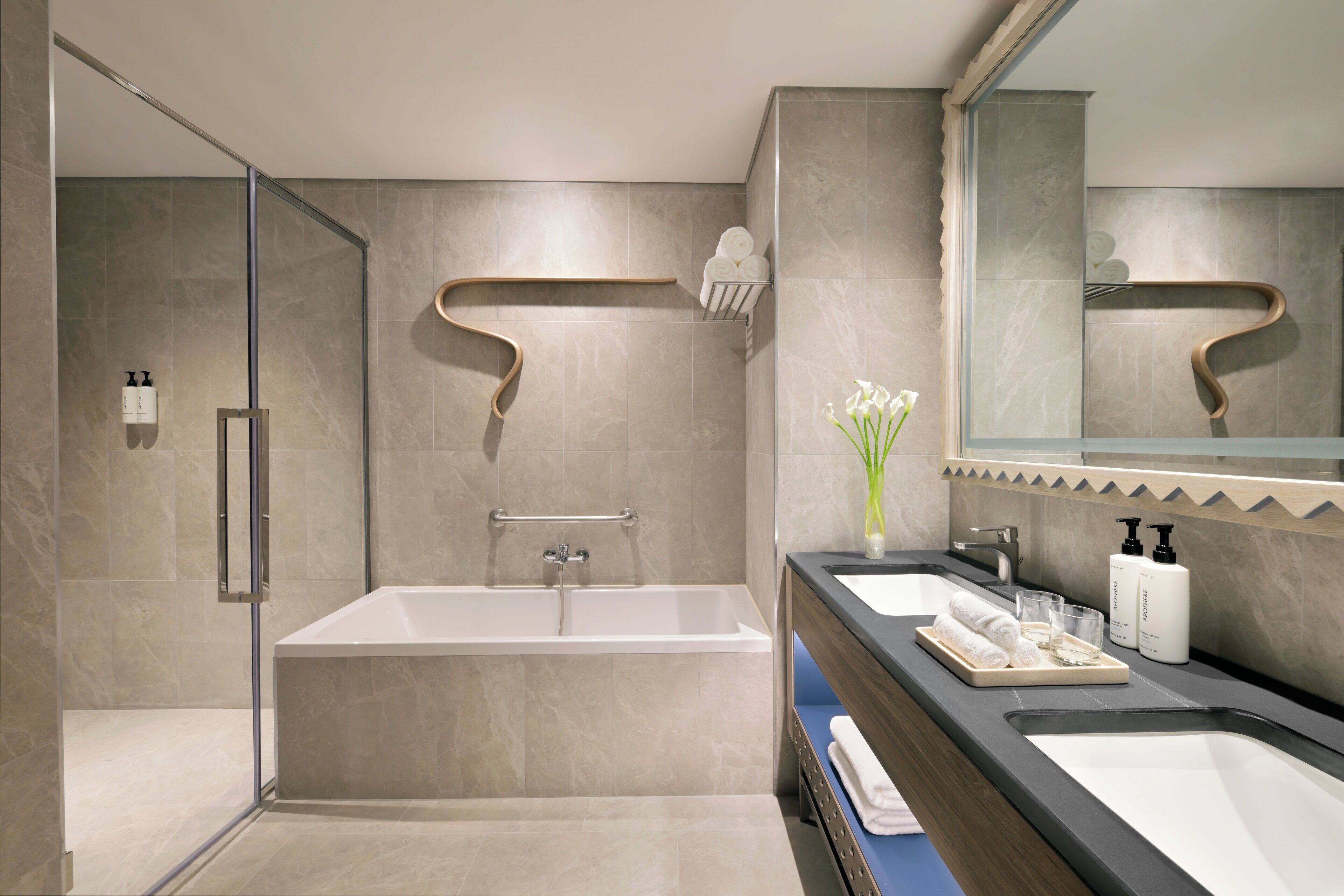 A modern bathroom with a bathtub, a shower, and a vanity with a mirror.