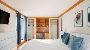 A bedroom with a bed, a desk, and a walk-in closet. - Contemporary 2 Bed 2 Bath Apt Bright and Sunny (New York)