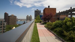A rooftop terrace with a city view, a pergola, and a pathway. - Fully Furnished 1BR in Murray Hills (New York)