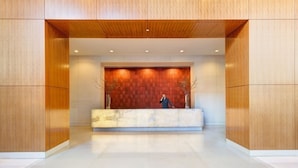 A reception area with a wooden reception desk and a marble counter. - Bright 2 Bedrooms 2 Bathrooms Unit With Balcony (New York)