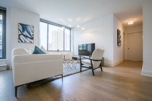 Ein modernes Wohnzimmer mit einem weißen Sofa, einem Couchtisch und einem Fernseher.