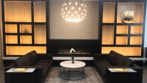 A modern living room with a fireplace, two sofas, a coffee table, and a decorative light fixture. - 2 Bed Apt Ideally Located in UES of Manhattan (New York)