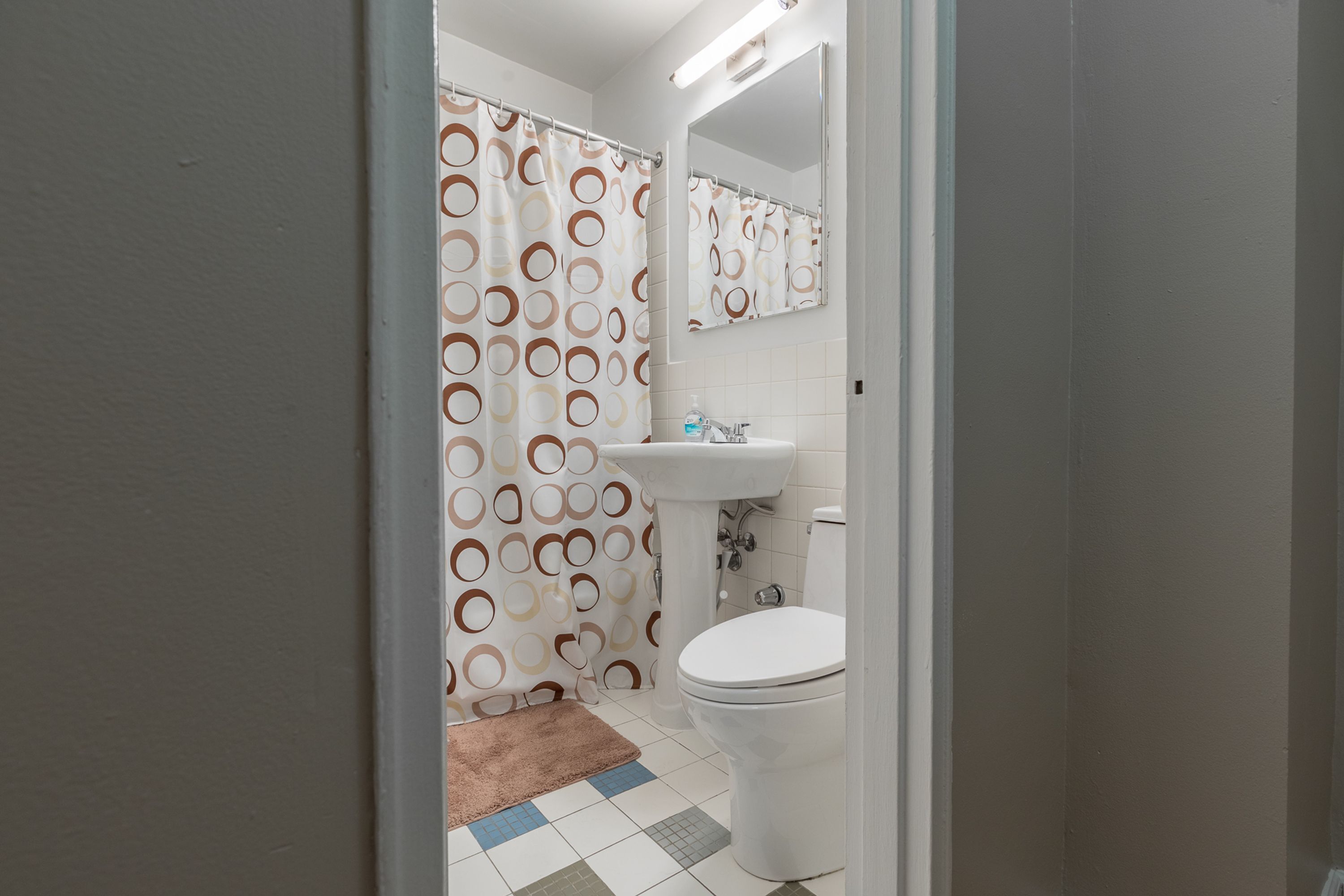Une salle de bain équipée de toilettes, d’un lavabo et d’un rideau de douche.