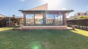 A modern house with large glass windows, a patio, and a well-maintained lawn. - The garden of Seba, a splendid detached villa surrounded by greenery (Piana Calzata)