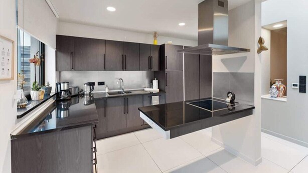 A modern kitchen with dark cabinetry, a black countertop, and stainless steel appliances. - Elegant & Spacious House close to Center (Kortrijk)