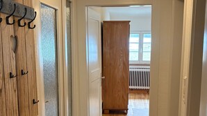 A hallway with wooden flooring, a rug, and a door with a 'HOME' sign. - Apartment 'Landliebe' with Mountain View, Shared Terrace, and Wi-Fi (Münstertal)
