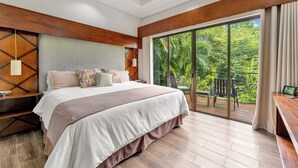 A modern bedroom with a large bed, wooden headboard, and a balcony with a view of lush greenery. - Casa Lumina – Contemporary 3-Bedroom Villa with Private Pool - 6 Guests (Playas del Coco)