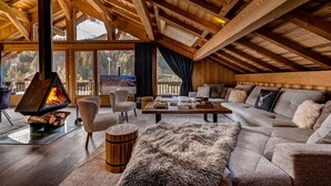 Un accogliente loft con camino, posti a sedere confortevoli e ampie finestre vista all'esterno.
