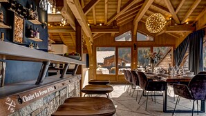 Un ristorante con arredi in legno, zona bar e tavoli da pranzo.