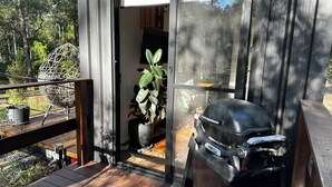 Eine moderne Terrassenausstattung mit Grill und Topfpflanzen.