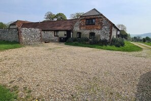 A rustic stone building with a gravel driveway and a grassy area. - Farm Life Retreat - 2 Houses (Offham)