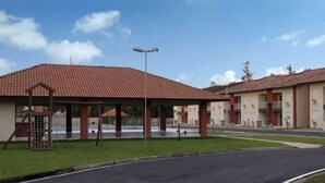 A building with a red-tiled roof, a covered outdoor area, and a paved entrance. - Apartment in Belém with swimming pool and 24-hour security. (Belém)