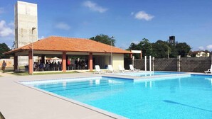 A swimming pool with lounge chairs and a covered pavilion. - Apartment in Belém with swimming pool and 24-hour security. (Belém)