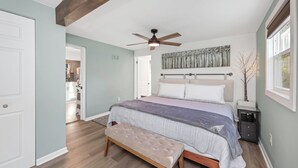 A bedroom with a bed, a bench, a ceiling fan, and a window. - Modern 3-BedRoom House
Large Deck, Firepit, Chef's kitchen, King Suite (Clearwater)