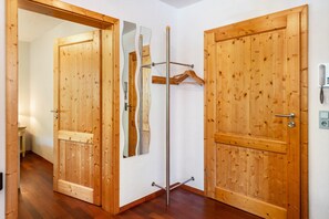 Une porte en bois avec un miroir, un porte-manteau et un téléphone.