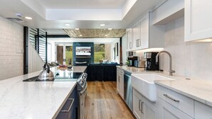 A modern kitchen with a central island, wooden flooring, and a view of the outdoors. - Managed by Park City Lodging-Easy Walk to Ski Lifts - Private Hot Tub - Views! (Park City)