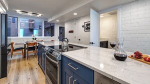 A modern kitchen with a large island, built-in appliances, and a view to the dining area. - Managed by Park City Lodging-Easy Walk to Ski Lifts - Private Hot Tub - Views! (Park City)