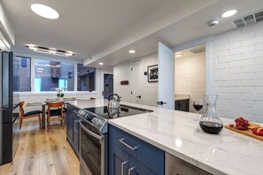A modern kitchen with a large island, built-in appliances, and a view to the dining area. - Managed by Park City Lodging-Easy Walk to Ski Lifts - Private Hot Tub - Views! (Park City)